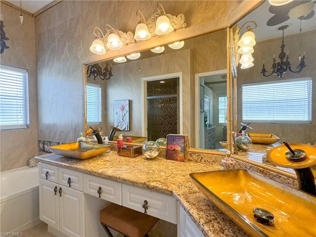 Bathroom featuring dual vanity and a washtub