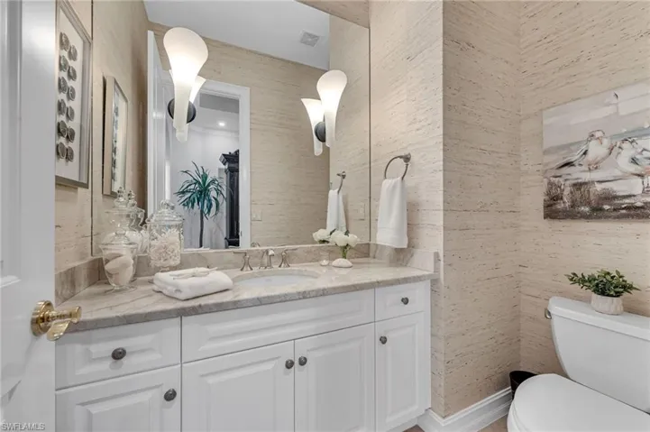 The Guest Powder room, located separately from the other guest suites, boast of Taj Mahal counters and coastal, woven wallpaper.
