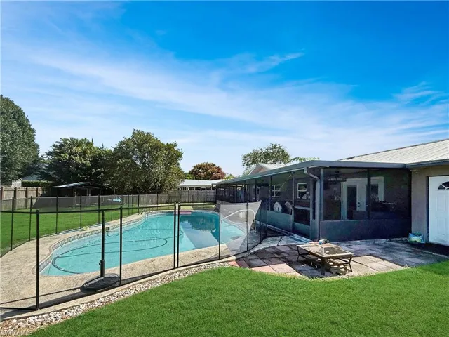 View of swimming pool with a sunroom, a patio area, and a fenced backyard