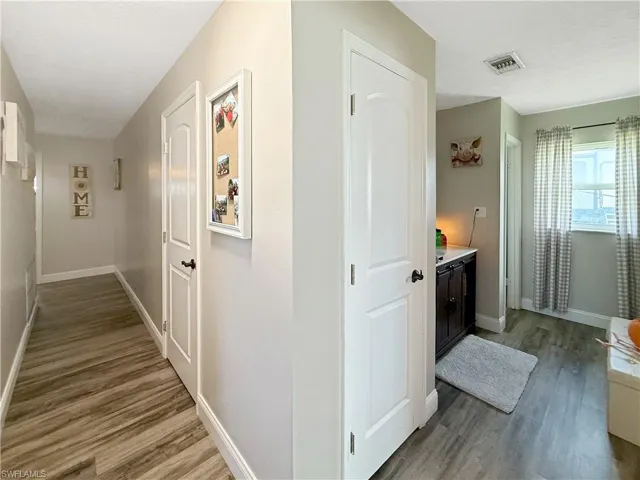 Hall with dark wood-style flooring and a textured ceiling
