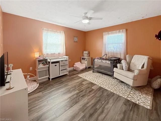 Bedroom featuring a textured ceiling, wood finished floors, and ceiling fan