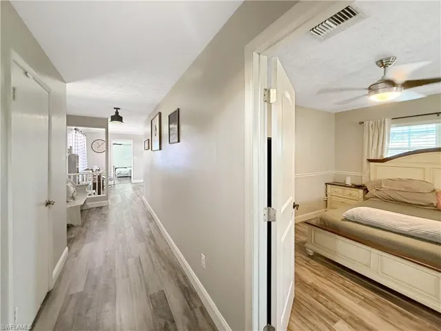 Hallway featuring light wood-style floors and a textured ceiling