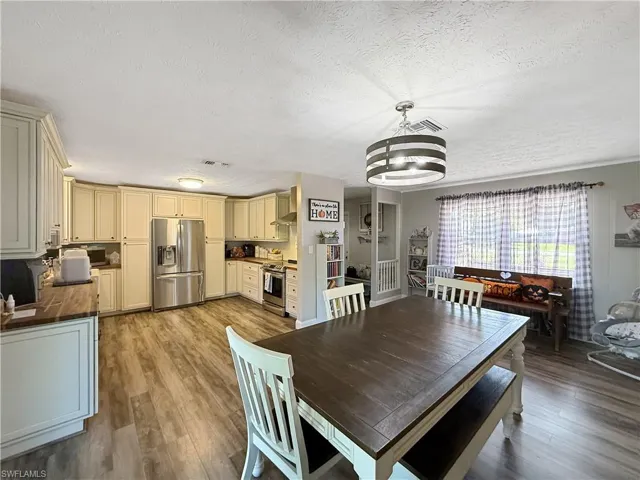 Dining room featuring light wood-style floors and a textured ceiling