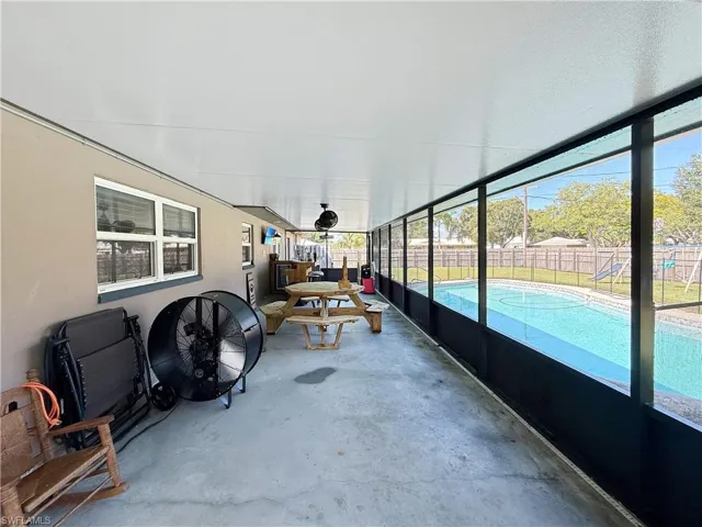 Sunroom / solarium featuring concrete floors and a patio