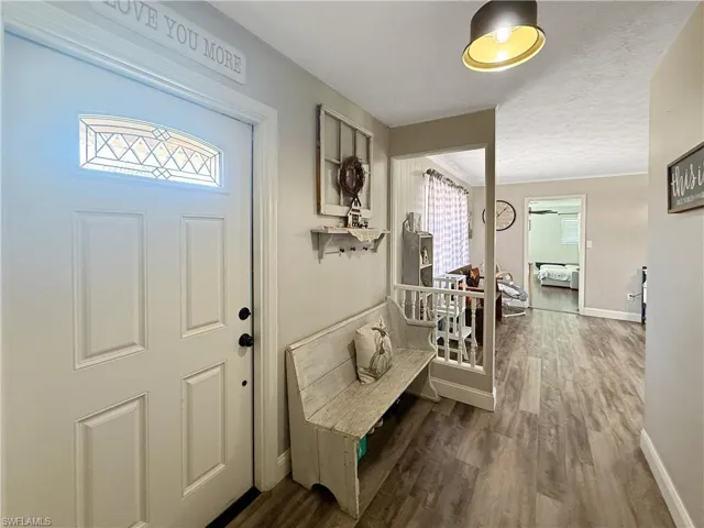 Entrance foyer with dark wood-type flooring and a textured ceiling
