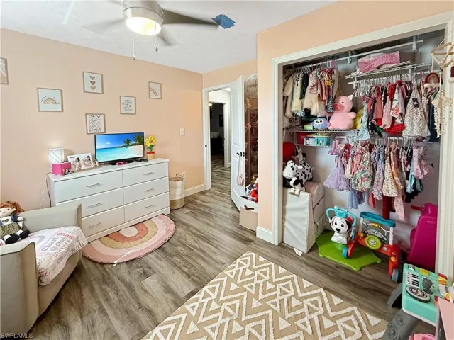 Bedroom with light wood-type flooring, a closet, and a ceiling fan