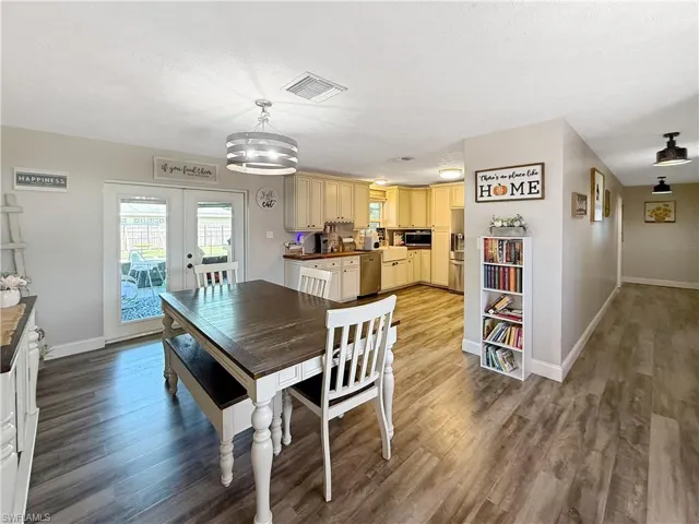 Dining room featuring light wood-style flooring, french doors, and a textured ceiling