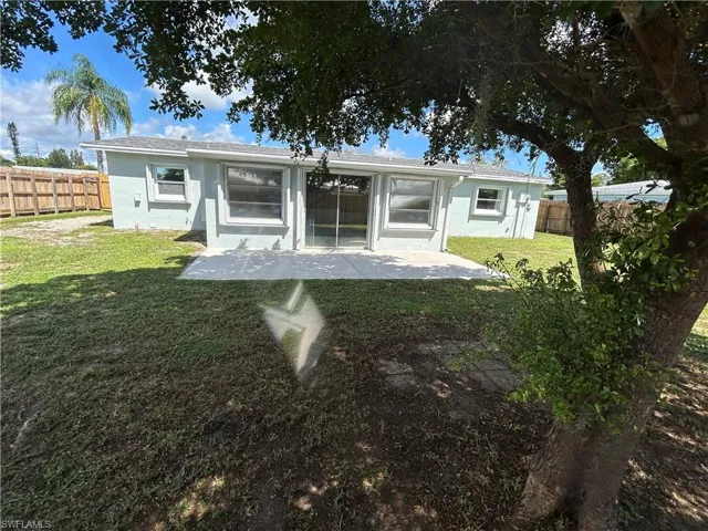 Back of property featuring a patio and a lawn