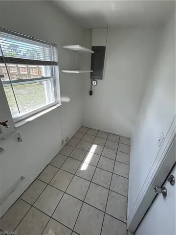 Spare room with electric panel and light tile patterned floors