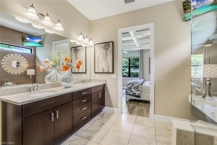 Owner's Bathroom featuring tile floors, vanity with extensive cabinet space, and dual sinks