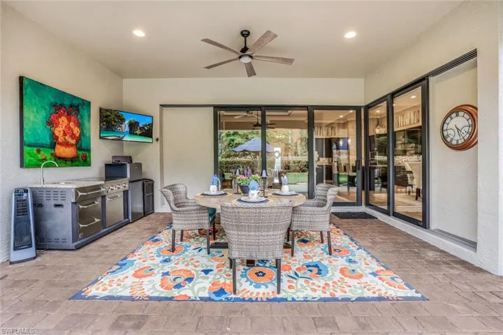 Lanai with retractable screen enclosure with portable outdoor kitchen. Plumbing and natural gas hook-up. Featuring zero corner impact sliding glass doors opening the outdoors in.
