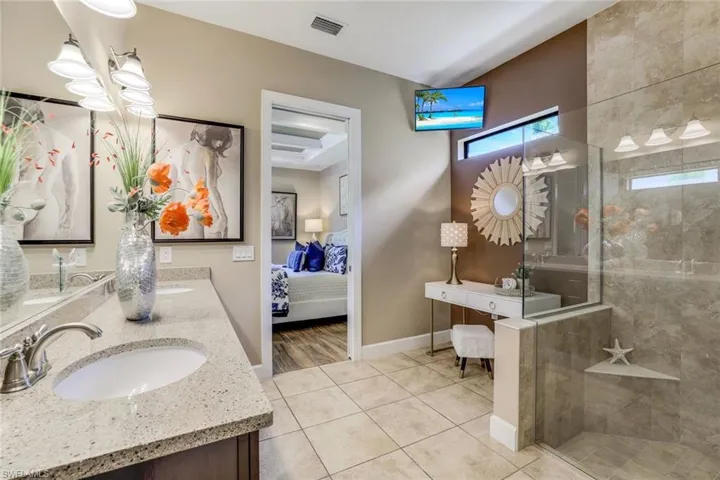 Owner's Bathroom with tiled shower, tile flooring, vanity, and a raised ceiling