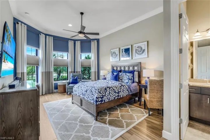Large secondary bedroom that can double as another owner's suite, tremendous ceilings, crown molding, bay window, ceiling fan, wood-like plank tile floor and ensuite bathroom