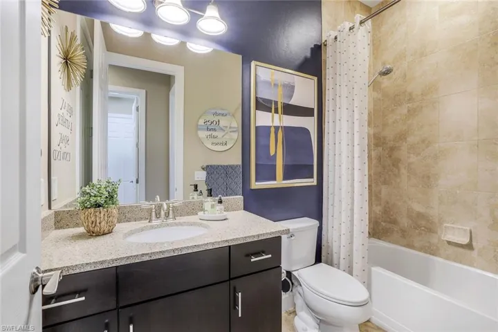 Full bathroom with shower / bath combo with shower curtain, toilet, and large vanity