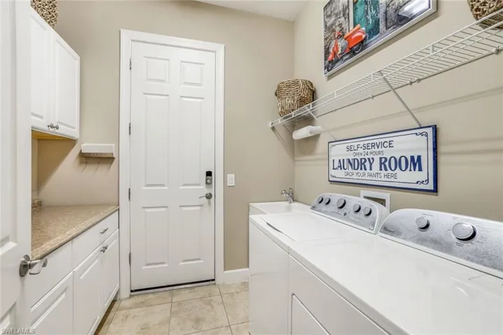 Great laundry room with extra cabinets and folding area with washer and dryer.