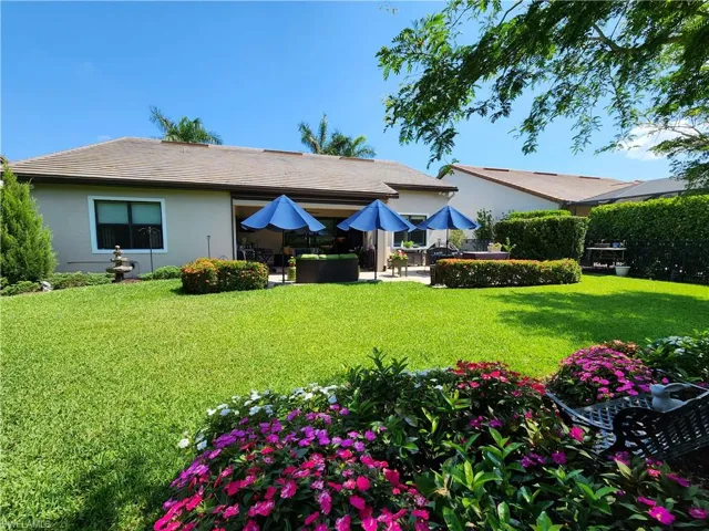 Rear view of property with a extended patio and a lawn.  Private large yard, beautifully landscaped and completed fenced in.