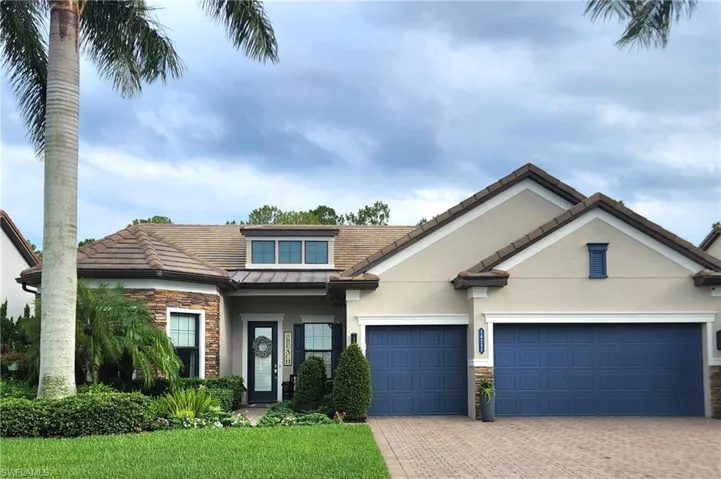 View of front of home with a beautifully landscaped, mature front yard, with three car garage that is extended 4' in depth. Extremely private lot with a large lake view as your front view