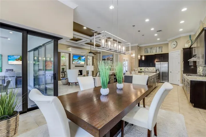 Tiled dining area featuring custom wall mirror and chandelier