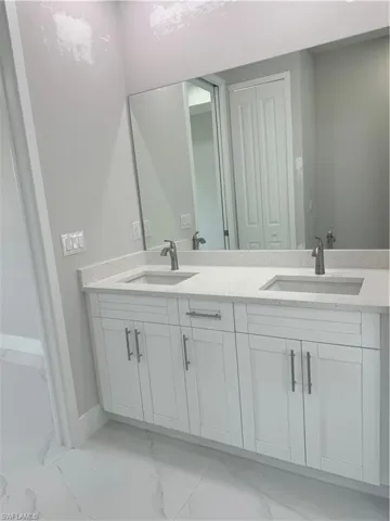 Bathroom with double vanity and tile patterned floors