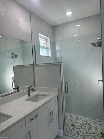 Bathroom with a shower with door and dual bowl vanity