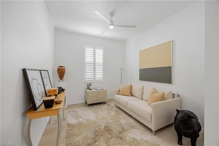 Living area with a ceiling fan and baseboards
