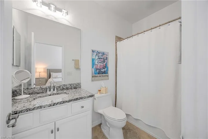 Full bathroom with vanity, shower / tub combo with curtain, and ensuite bathroom
