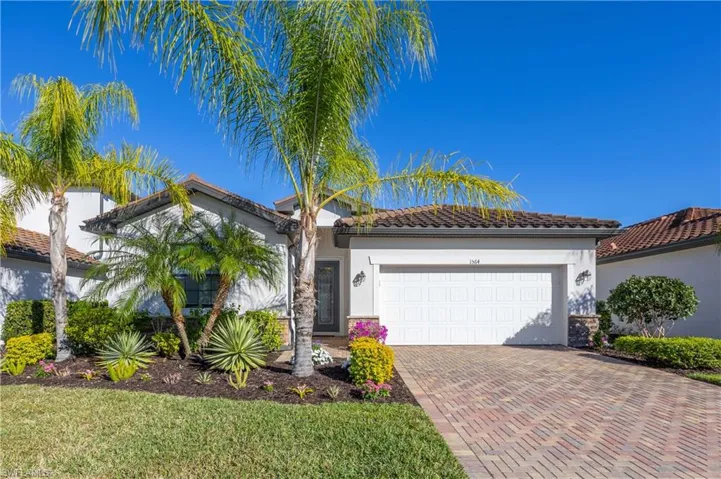 Mediterranean / spanish-style home featuring a tiled roof, decorative driveway, stucco siding, and a garage