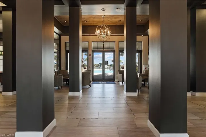 Entrance foyer featuring hanging lights, light wood-style flooring, and a high ceiling