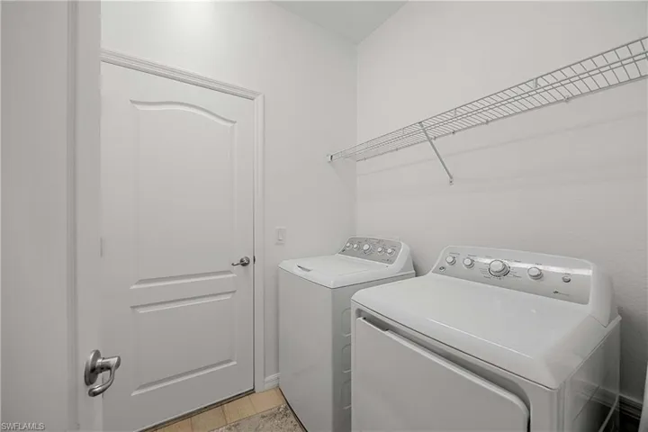 Laundry area with independent washer and dryer and light wood-type flooring