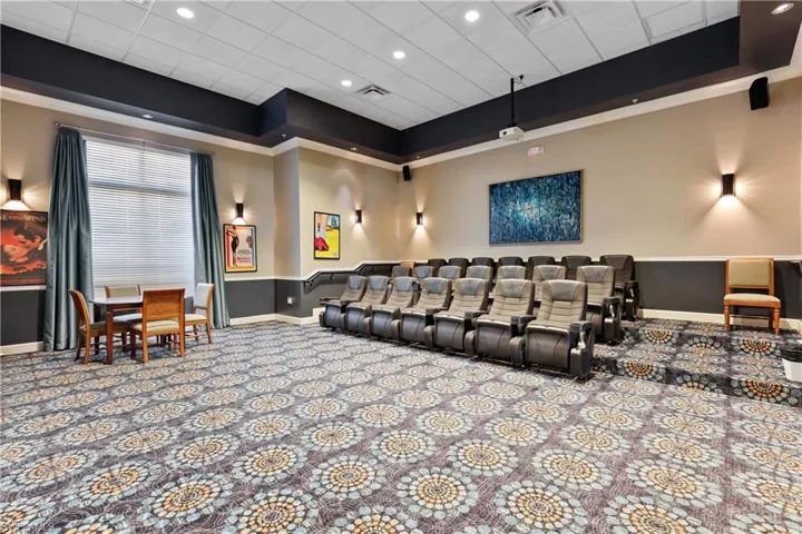 Carpeted cinema room with a tray ceiling, recessed lighting, and a paneled ceiling