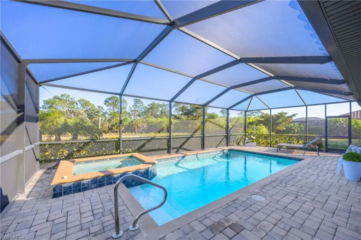 Integrated pool / spa with a sunroom, a lanai, and a patio