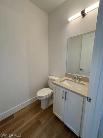 Bathroom with wood-type flooring, toilet, and vanity