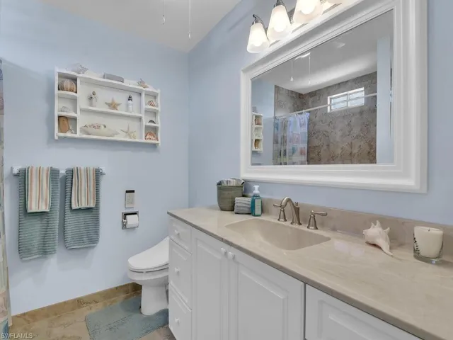 Bathroom with vanity, toilet, and a shower with curtain