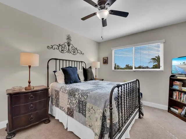 Carpeted bedroom featuring baseboards and ceiling fan