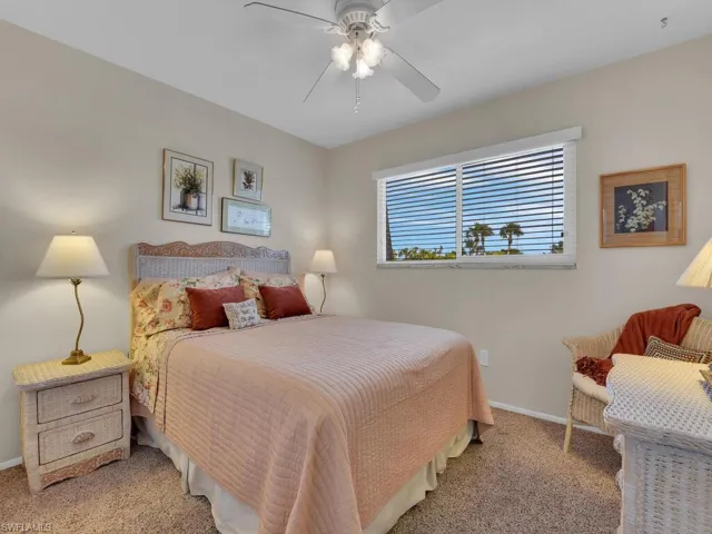 Carpeted bedroom with baseboards and a ceiling fan