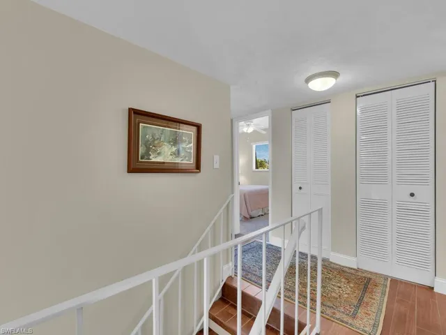 Hall featuring an upstairs landing, baseboards, and wood finished floors