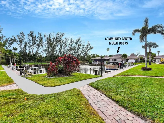 View of community with a boat dock, boat lift, a lawn, and a water view