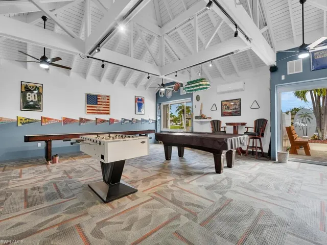 Recreation room featuring a ceiling fan, light carpet, rail lighting, beam ceiling, and high vaulted ceiling