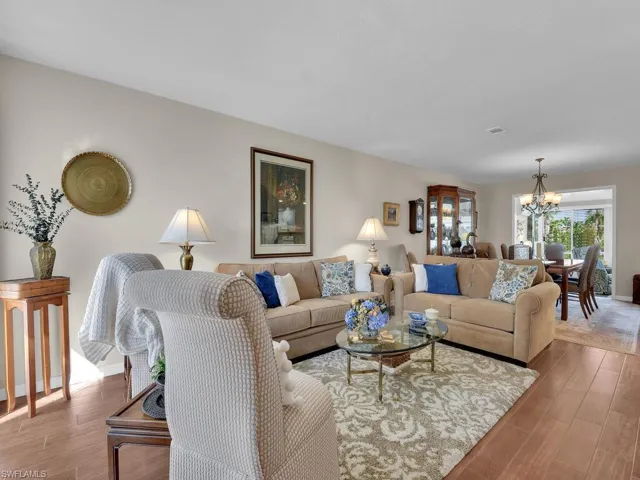 Living room featuring a chandelier, wood finished floors, and baseboards