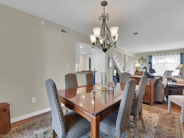 Dining area with stairway, a chandelier, light wood-style floors, and baseboards