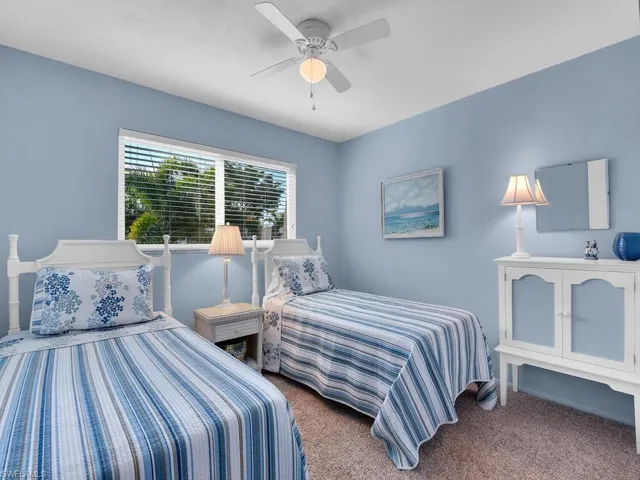 Carpeted bedroom featuring ceiling fan