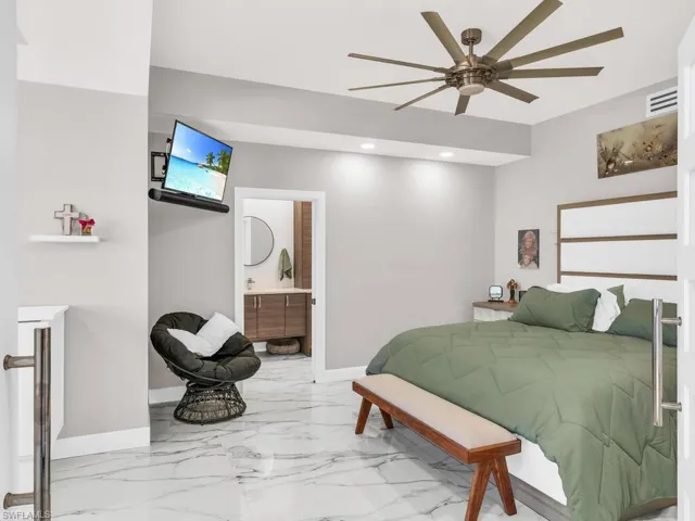 Bedroom featuring ceiling fan and ensuite bath