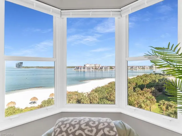 Sunroom featuring a view of the beach and a water view