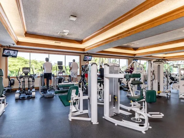 Exercise room with a tray ceiling, a textured ceiling, and ornamental molding