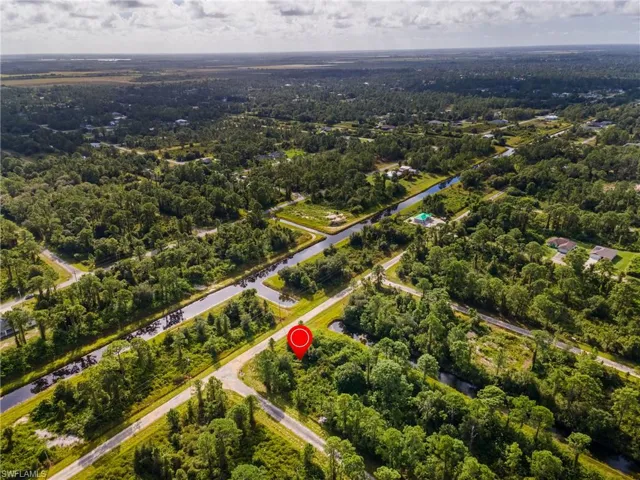 Aerial view of property and surrounding area featuring a forest