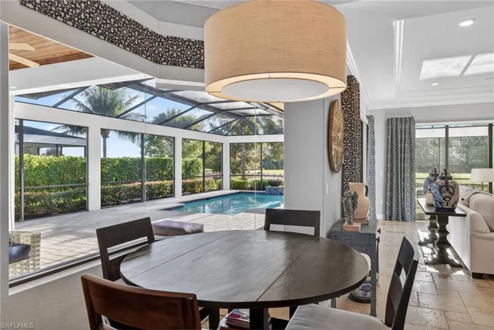 Dining room with stone tile flooring, a sunroom, crown molding, and recessed lighting