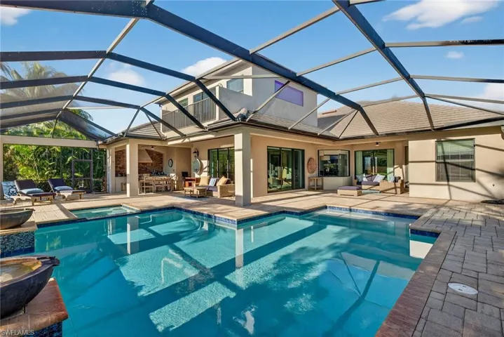 View of swimming pool with a sunroom, a patio area, outdoor lounge area, glass enclosure, and a pool with connected hot tub