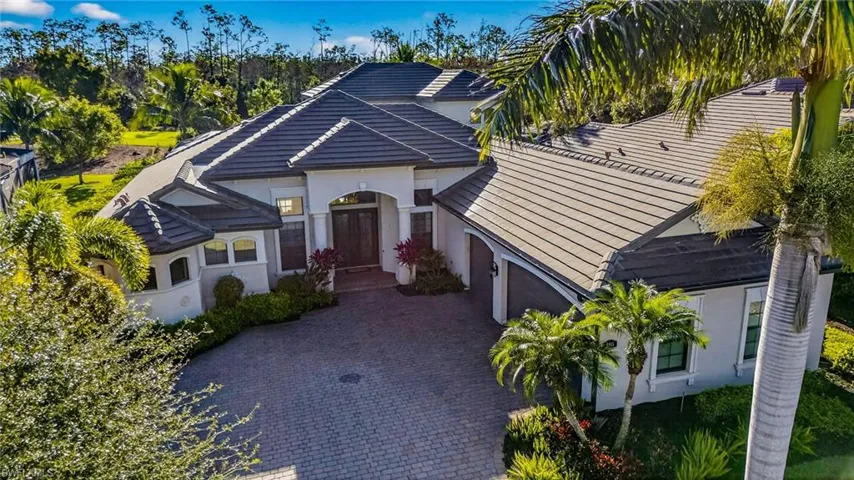 View of front of property with stucco siding, a tiled roof, and decorative driveway