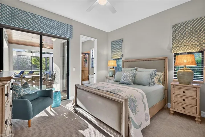 Bedroom with access to exterior, carpet flooring, a ceiling fan, and ensuite bathroom