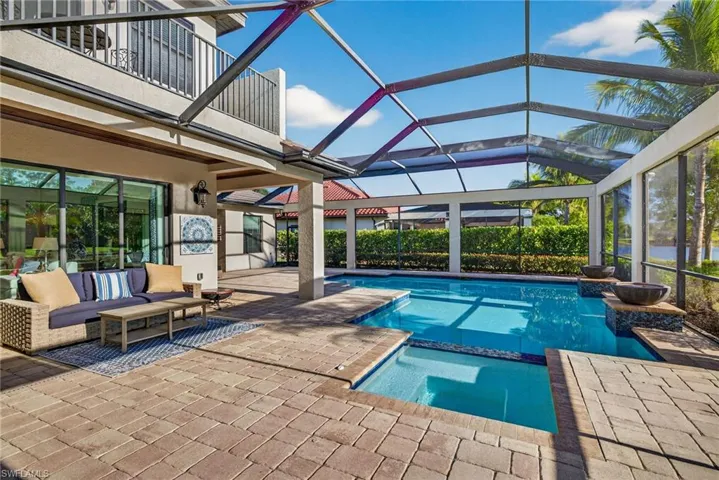 View of swimming pool featuring a lanai, a patio area, a sunroom, and a pool with connected hot tub